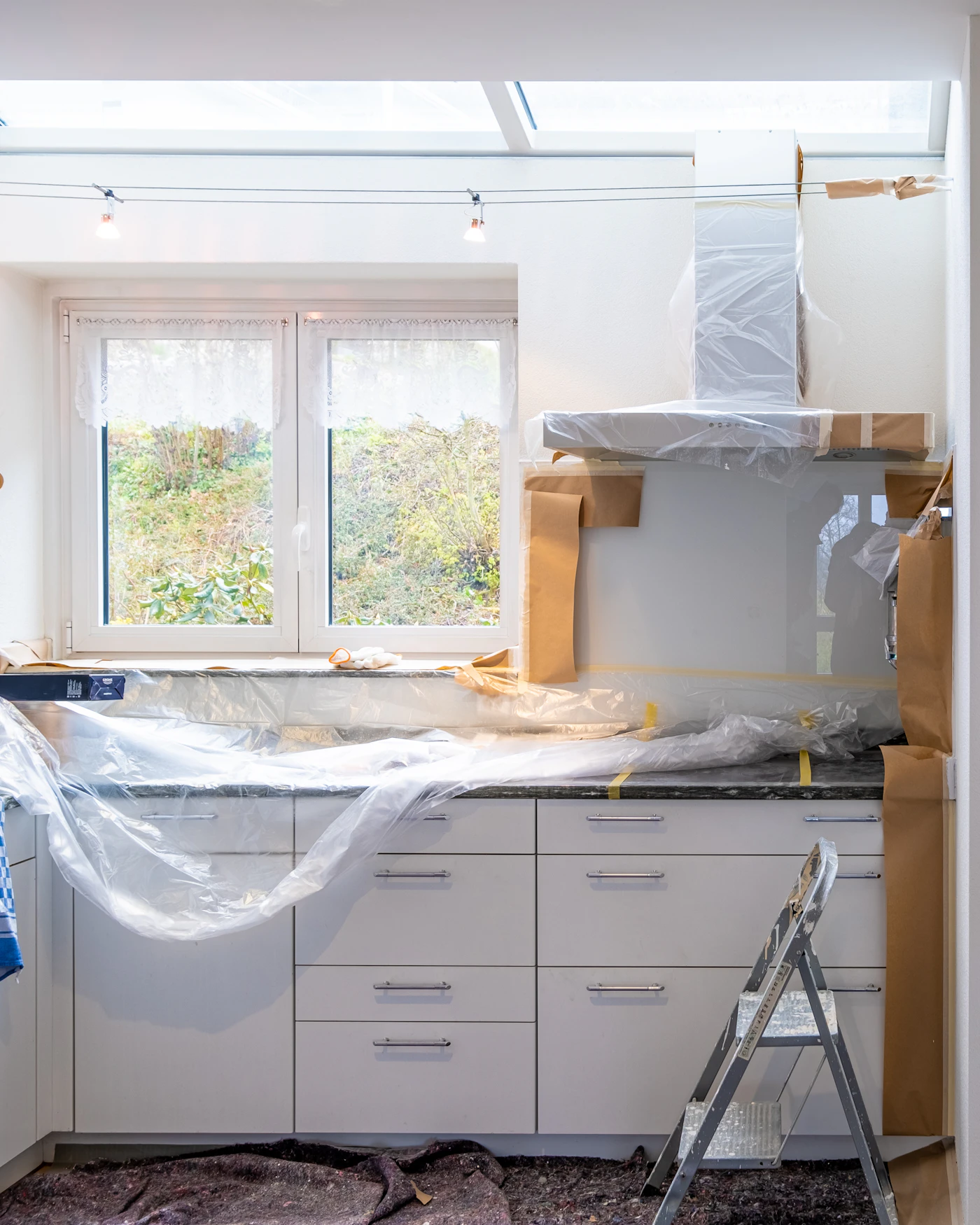 Cozinha em obras com móveis protegidos por plástico