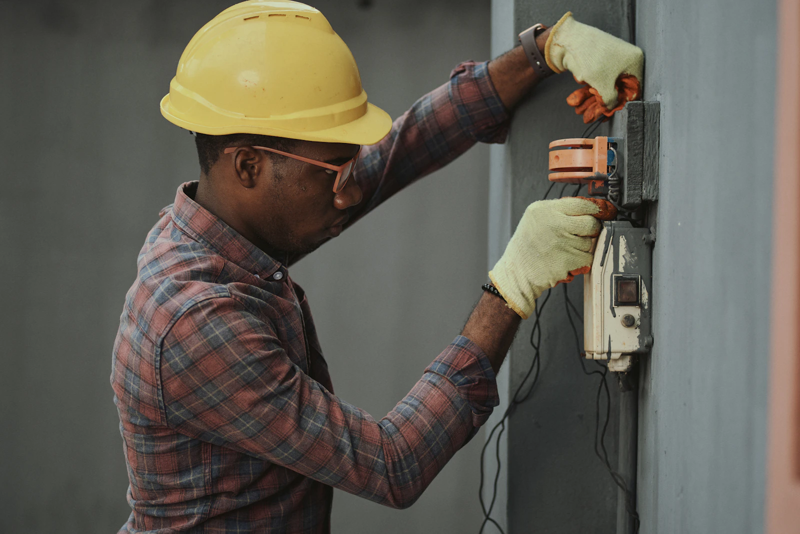 Técnico com capacete a trabalhar numa instalação de parede